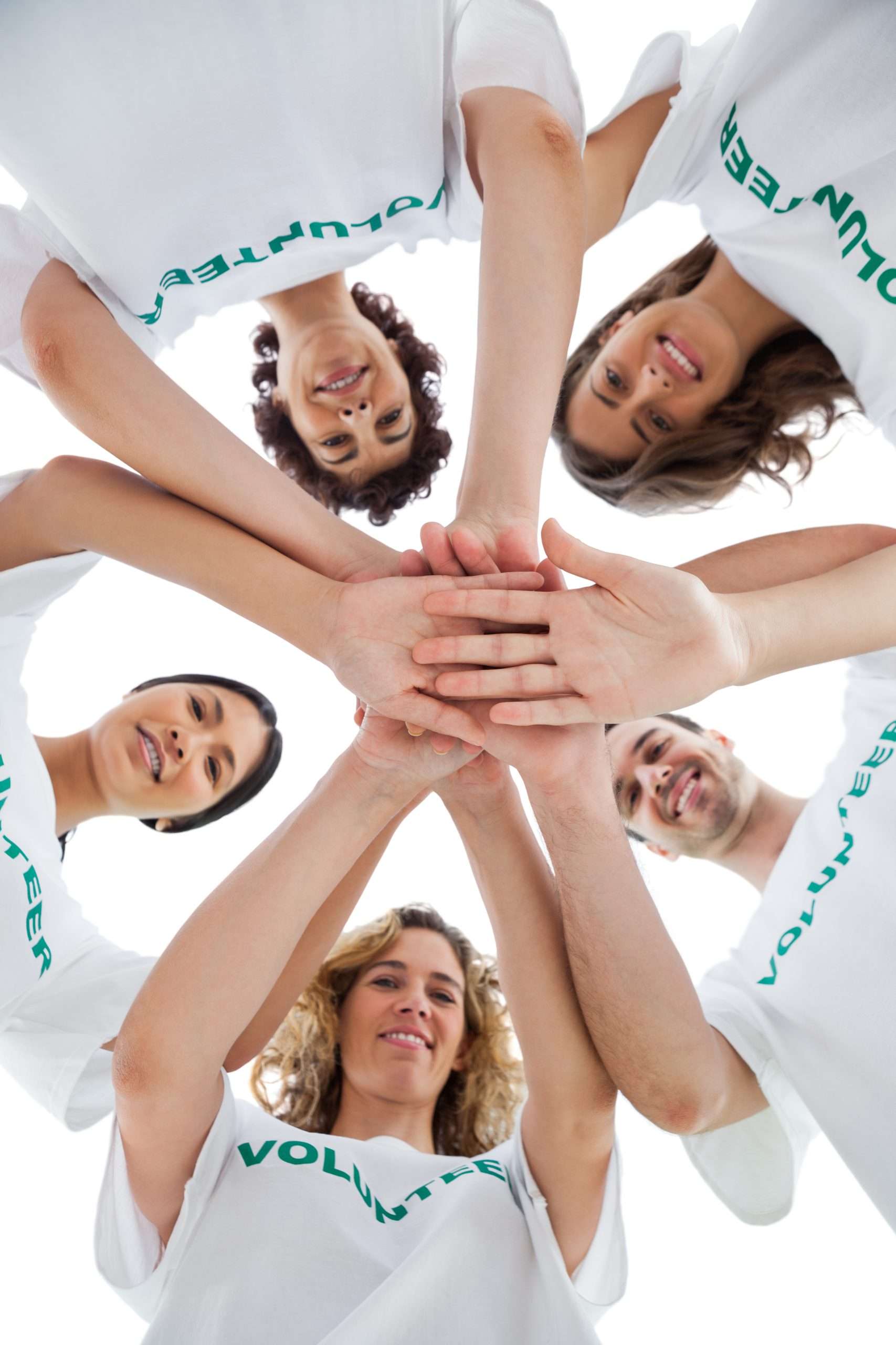 Smiling group of volunteers piling up their hands