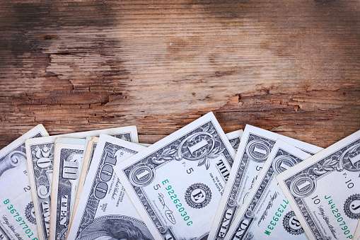dollar banknotes on wooden surface closeup top view background