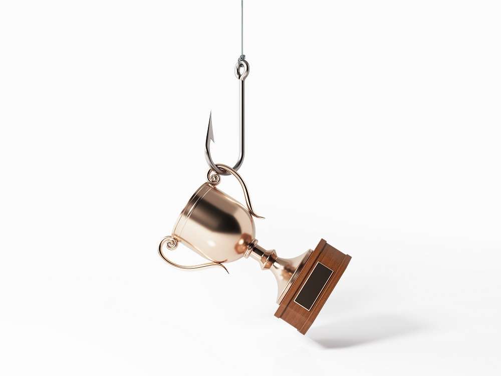 Trophy Hooked By A Fishing Hook - Bait Concept Trophy hooked by a fishing hook on white background.