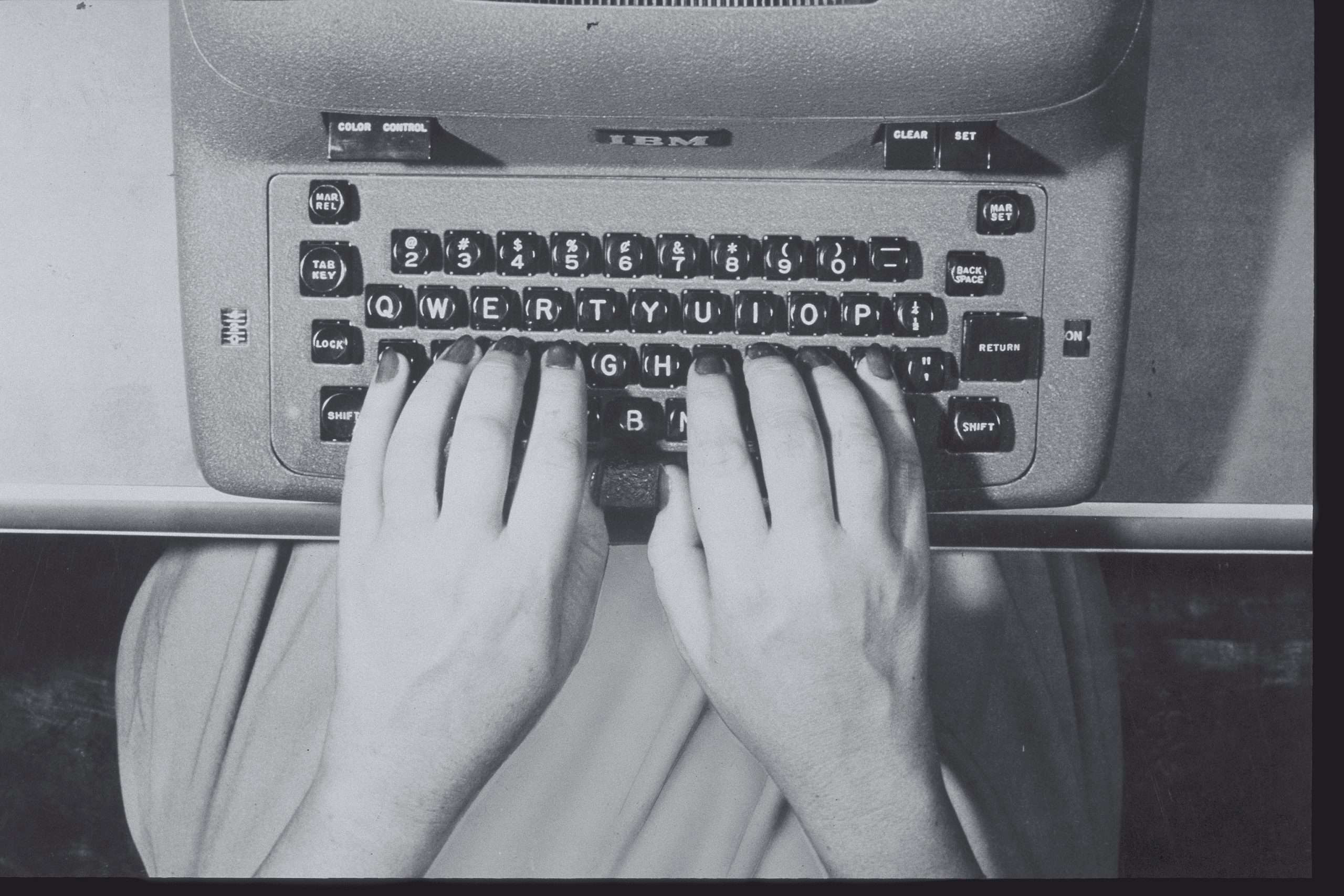 WOMANS HANDS OVER KEYS OF TYPERWRITER